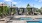 pool area with reclining seats and landscaping