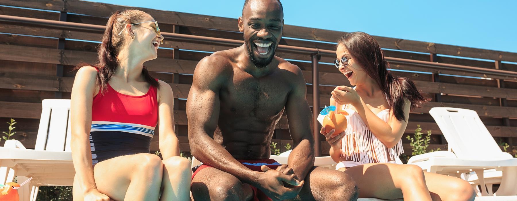 a person and two women sitting on a pool